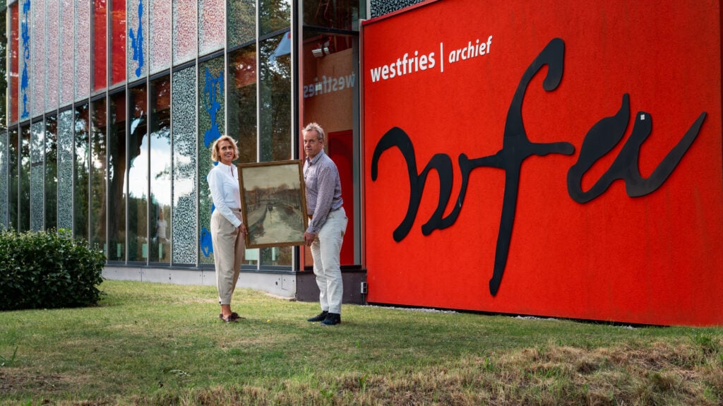 directeur van het westfries archief en voorzitter van de Vrienden tonen samen een ingelijste aquarel