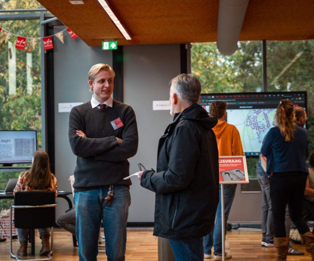 Stagiair Max Wieringa in gesprek met een bezoeker van het Westfries Archief