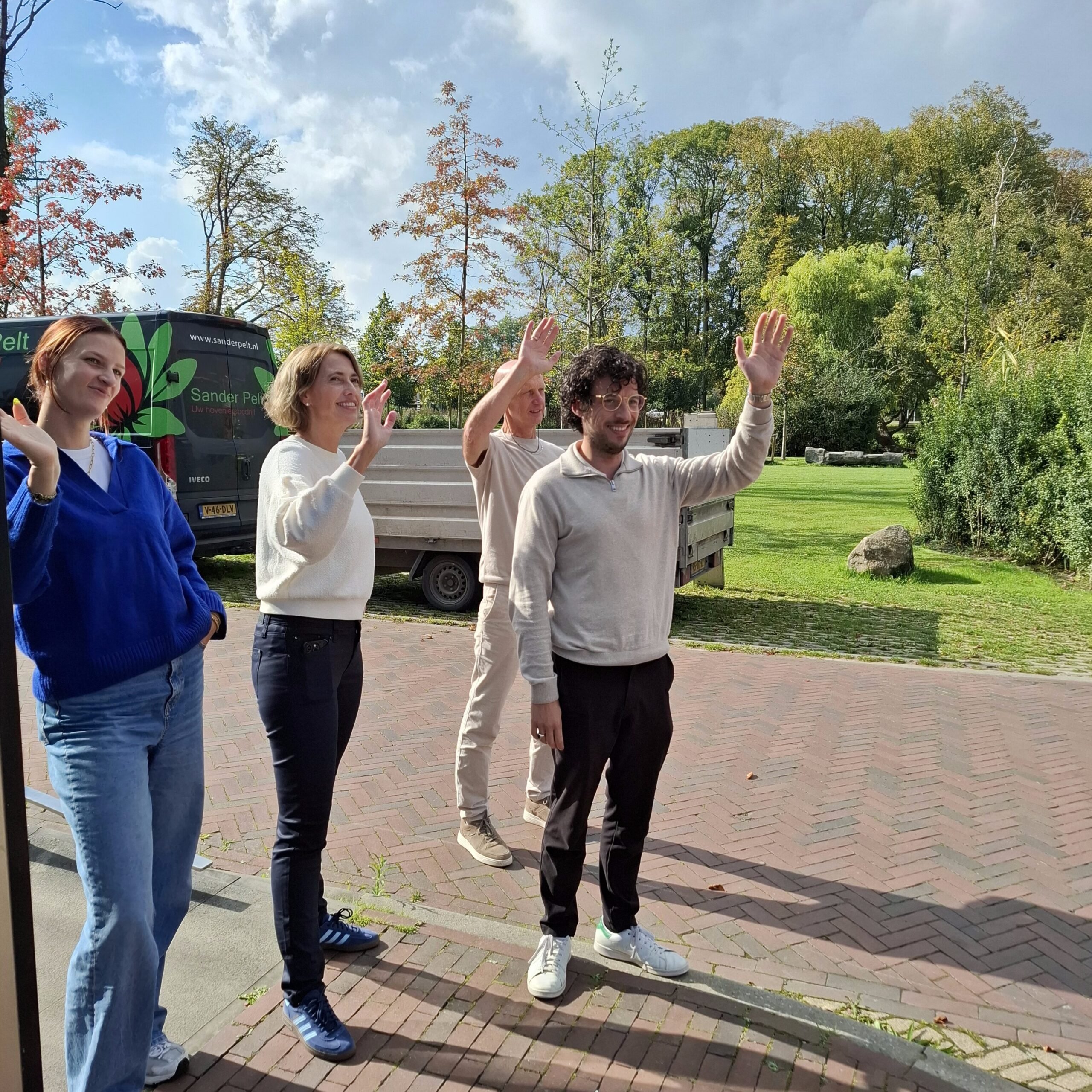 medewerkers van het Westfries Archief staan buiten en zwaaien 