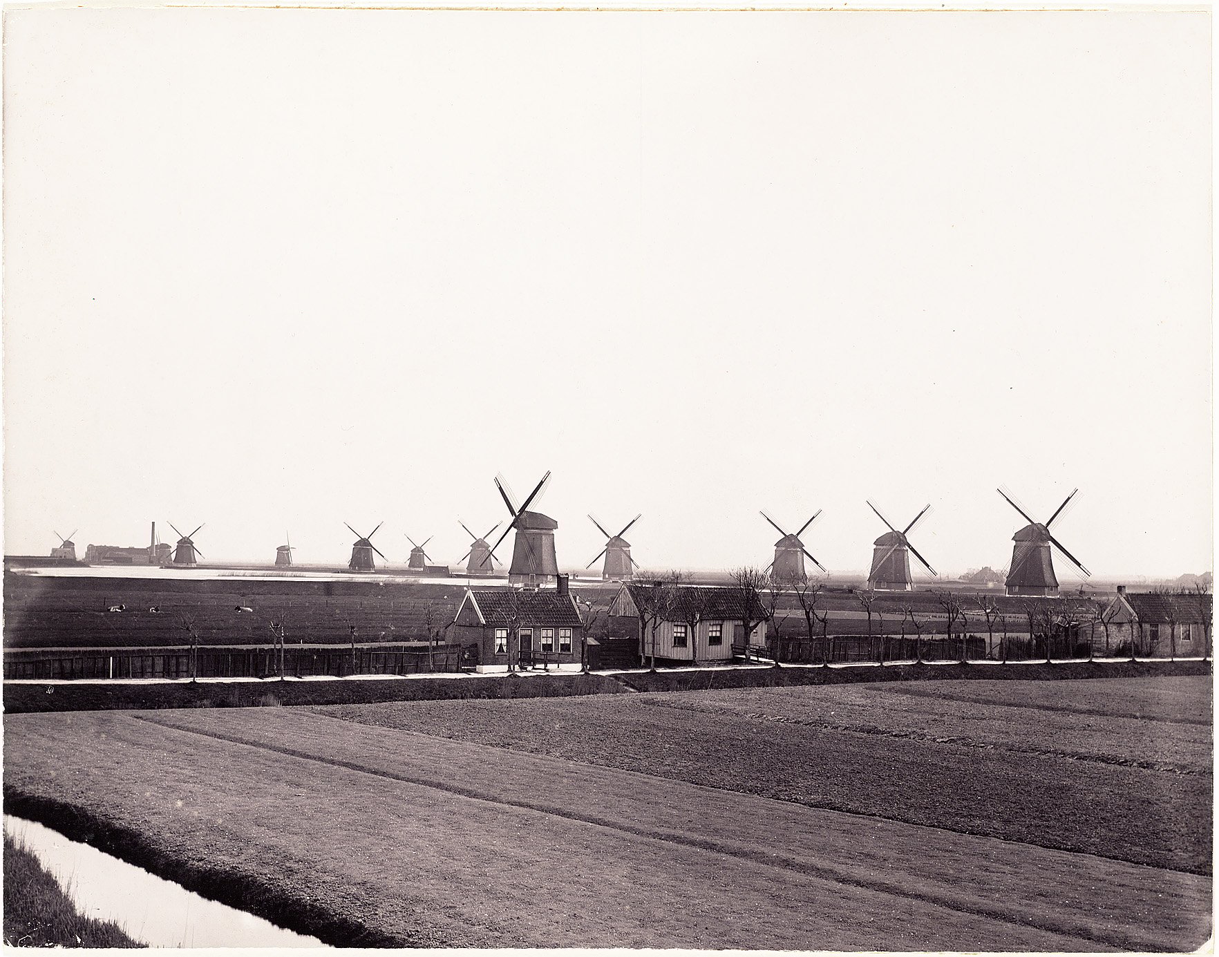 Watermolens van De Vier Noorder Koggen op de Oosterdijk bij Medemblik, gemaakt in 1900. Op de achtergrond is het stoomgemaal van De Vier Noorder Koggen te zien.