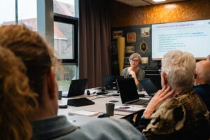 Deelnemers cursus stamboomonderzoek luisteren naar docent