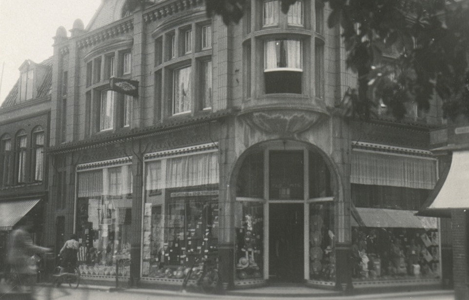 Foto van ‘Grootst Speciaalhuis voor Moderne Heeren- en Kinderkleeding, Hoeden, Petten, Sport- en Modeartikelen’ van G.J. Smits, gevestigd aan de Nieuwsteeg 22.